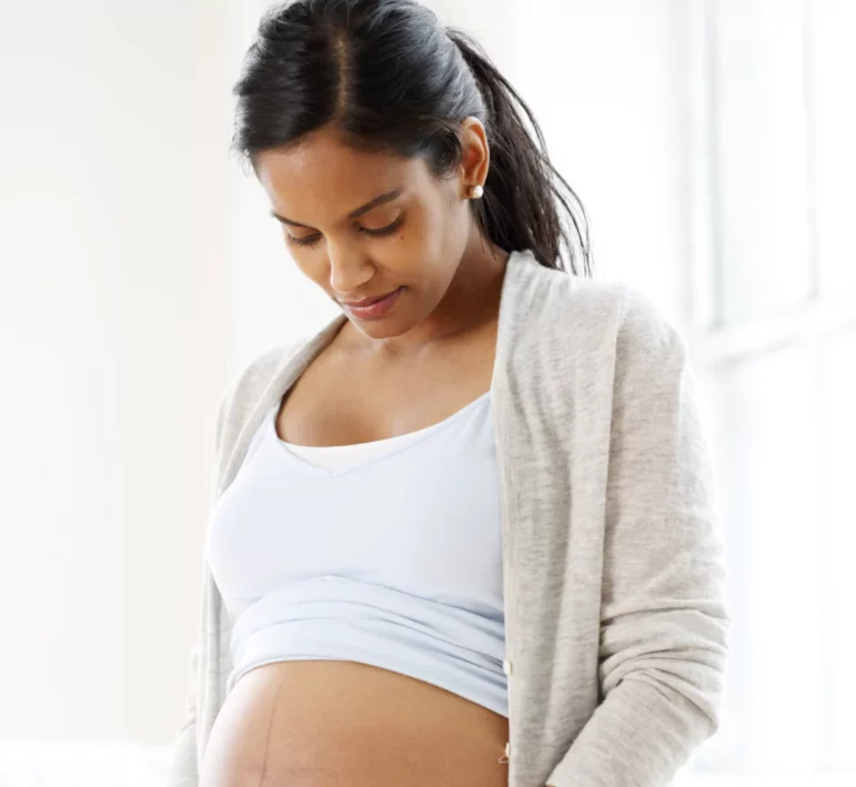 A pregnant woman holding her belly while in a birth prep course